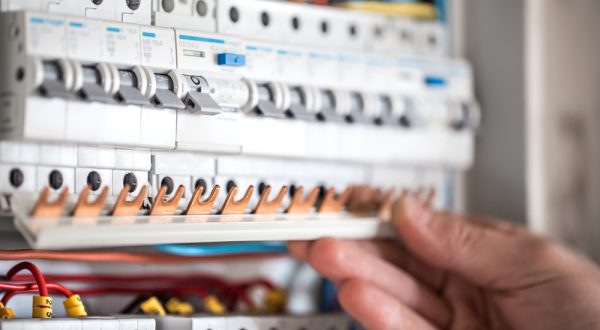 13852_field_service_image_man-electrical-technician-working-switchboard-with-fuses-installation-connection-electrical-equipment-close-up