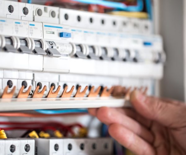 13852_field_service_image_man-electrical-technician-working-switchboard-with-fuses-installation-connection-electrical-equipment-close-up